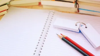 ノートと鉛筆、暗記カードが机に置かれている